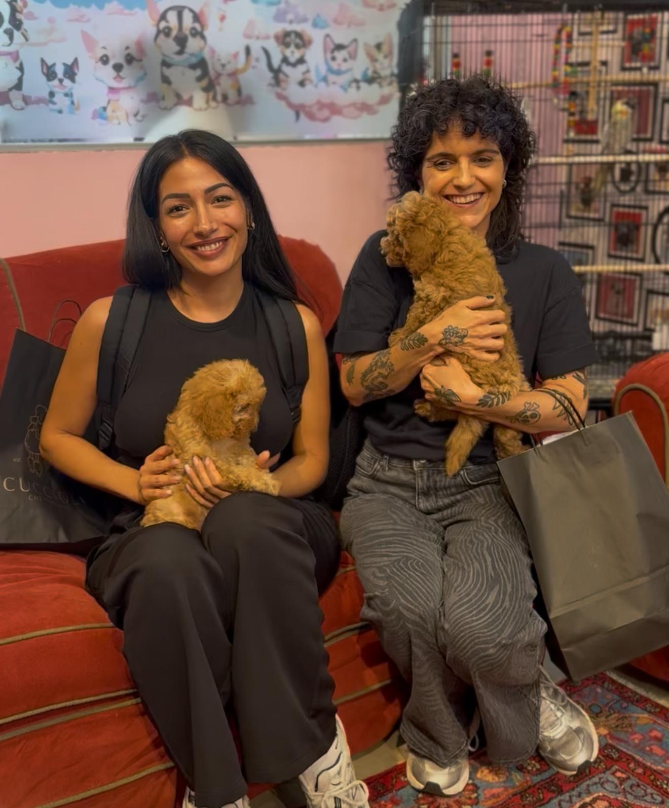 Deux sœurs de Genève tenant les deux chiots femelles caniches toy qu’elles ont adoptés